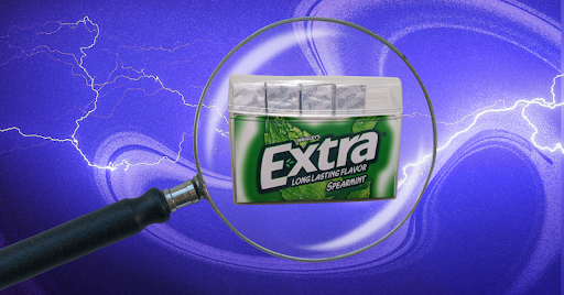 A magnifying glass hovers over a green pack of Wrigley’s gum against a purple background.