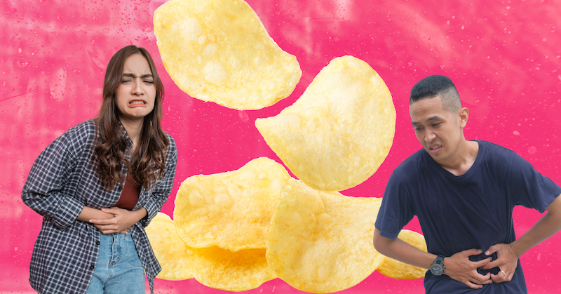 A man and woman hold their stomachs in pain. Behind them, are several oversized potato chips against a pink background.